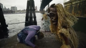 Omah Lay bowing to a masquerade in his new video for popular song Soso
